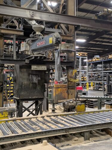 A Machine Inside Badger Foundry With A Conveyor.
