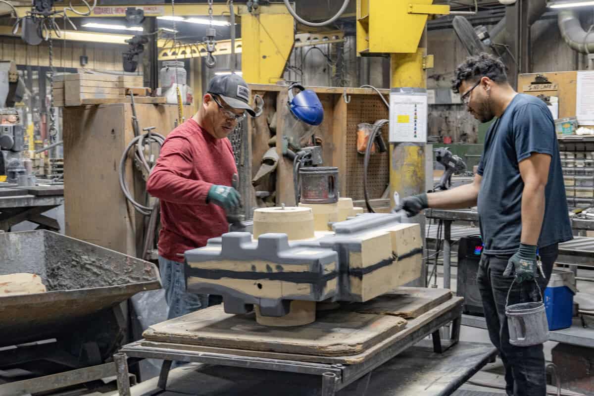 Two Men Working In Badger Foundry Applying Coating.