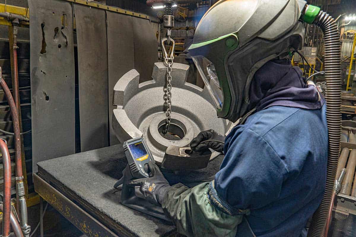 A Badger Foundry Employee Inspects The Inside Of One Of Their Parts