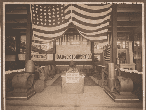 An Old Photo Of A Large Room With A Flag And A Sign That Reads Badger Foundry Co.