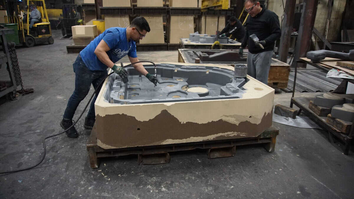 Badger Foundry Employees Working On A Mold In The Factory.