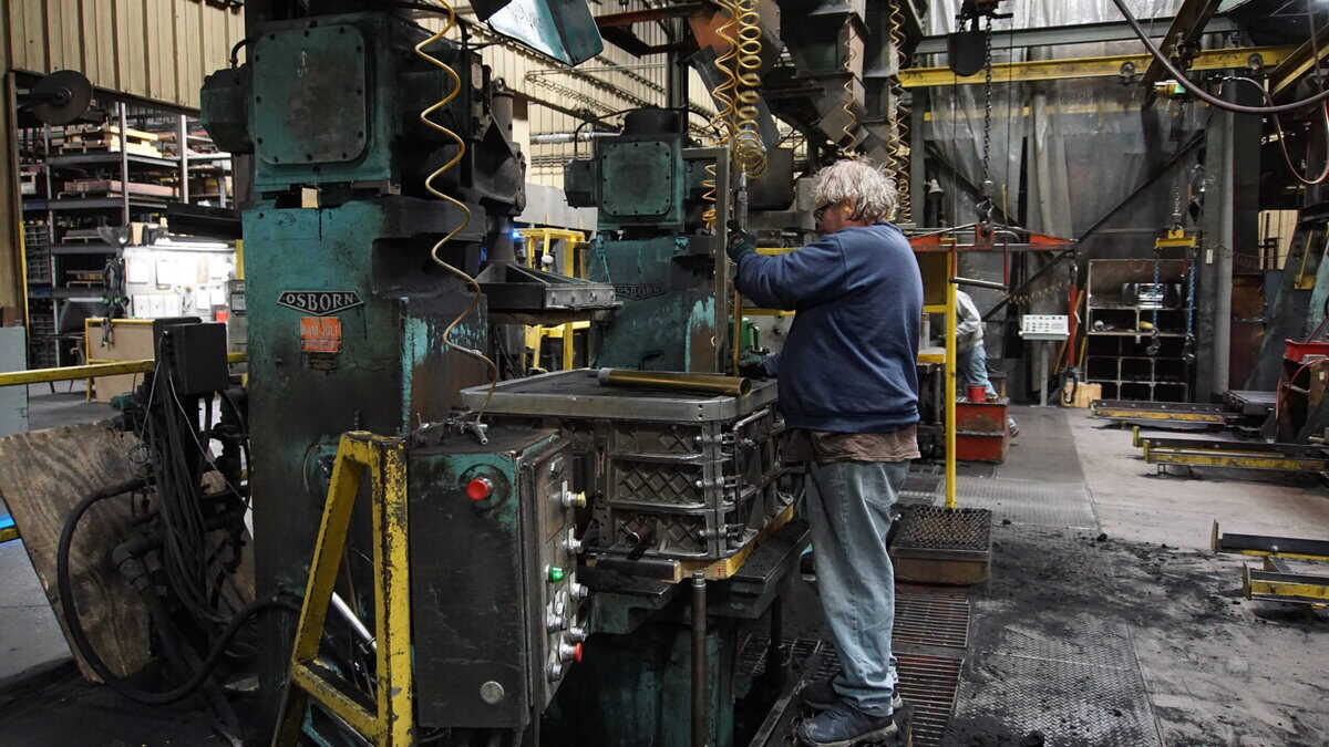 A Man Is Working On A Machine Made By Osborn Inside Of Badger Foundry
