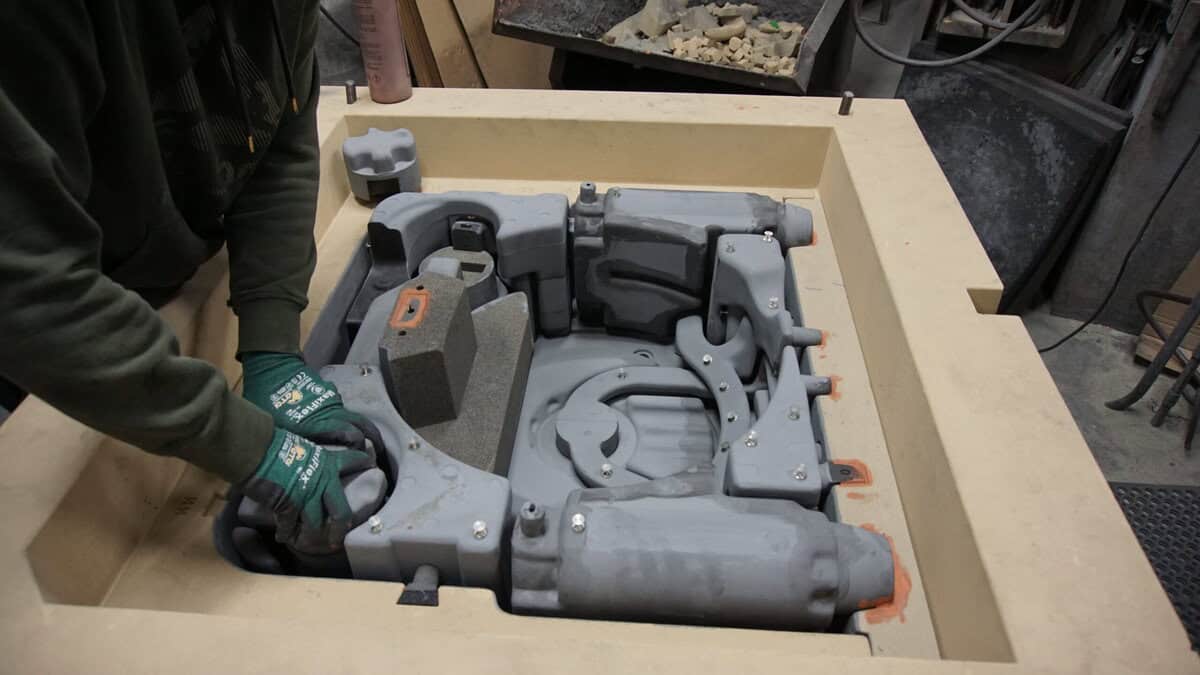 A Man Is Working On A Large Mold At Badger Foundry